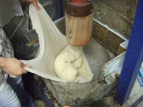 一升餅の作り方（２）　蒸し上がったもち米を石臼に入れます。